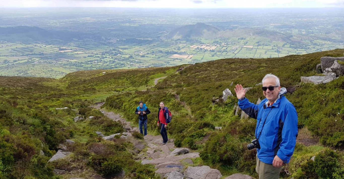 Man waving at the camera while hiking Slieve Gullion in Northern Ireland
