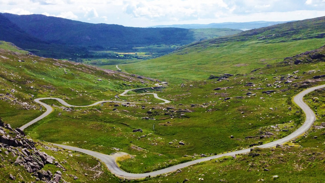 Twisting road and green mountains on the Healy Pass in Ireland