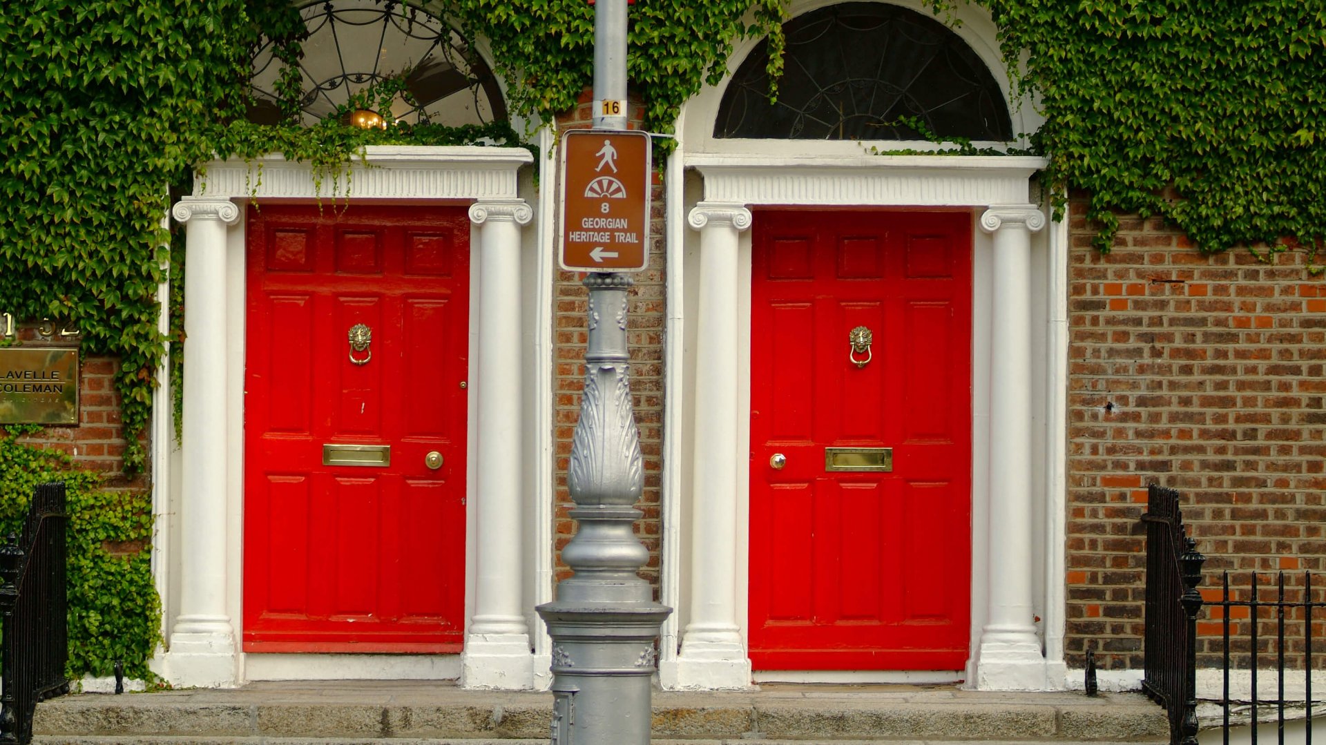 Two Georgian red doors in Dublin beautifully covered in Ivy