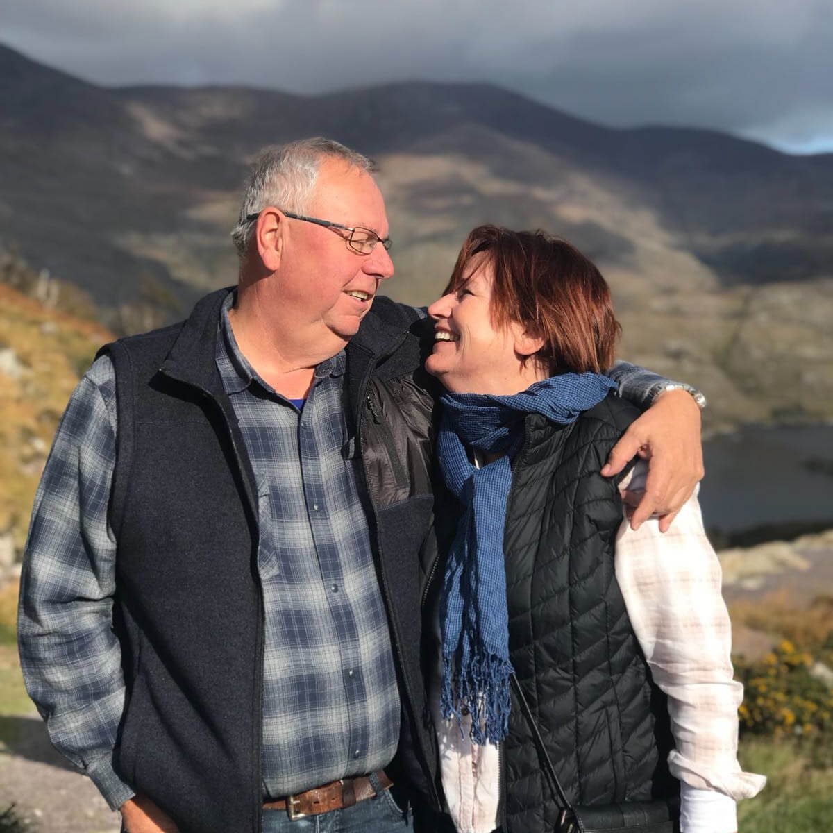 Middle aged couple look into each other's eyes in a scenic location in Ireland