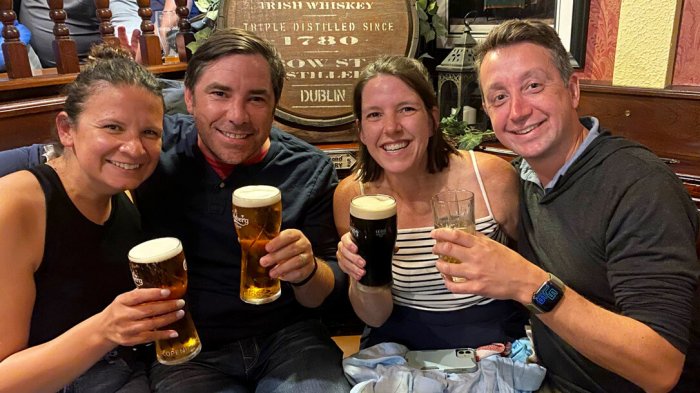 Happy tour group toasting pints of beer in Ireland