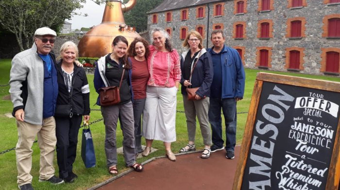 A smiling Driftwood tour group on a guided tour of the Jameson Whiskey Distillery in Midleton, Ireland