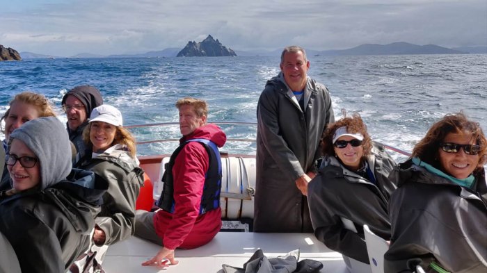 Smiling tour group on board a boat trip to the Skellig Islands, Ireland