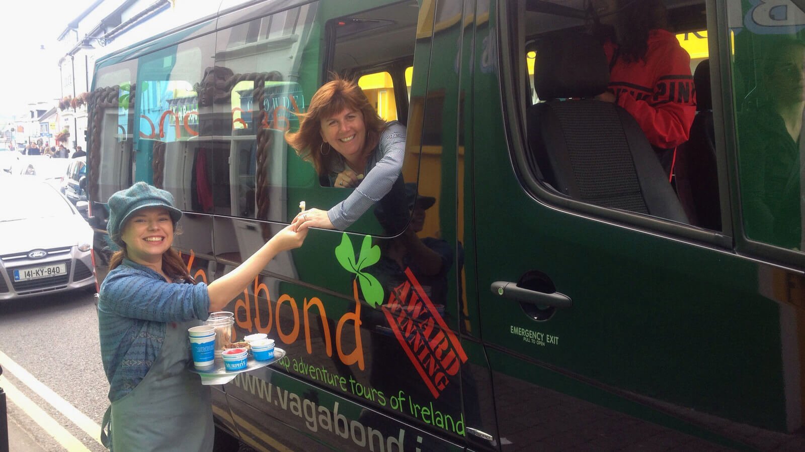 Murphy's Ice Cream staff giving samples to Vagabond guest through tour vehicle window in Dingle, Ireland