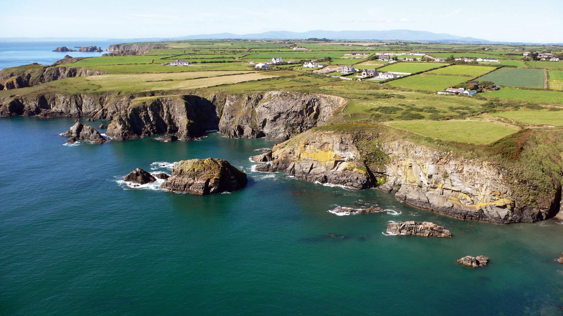 Sea, cliffs and patchwork green fields along the Copper Coast in Waterford