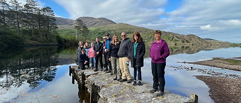2023 Ireland tour group standing on a pier beside a scenic lake