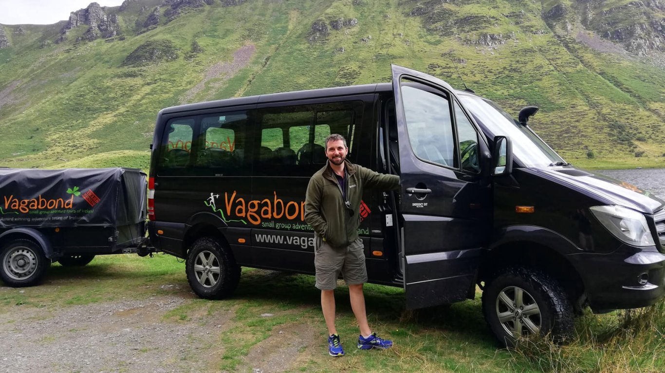 Tour guide standing at door of Mercedes tour vehicle