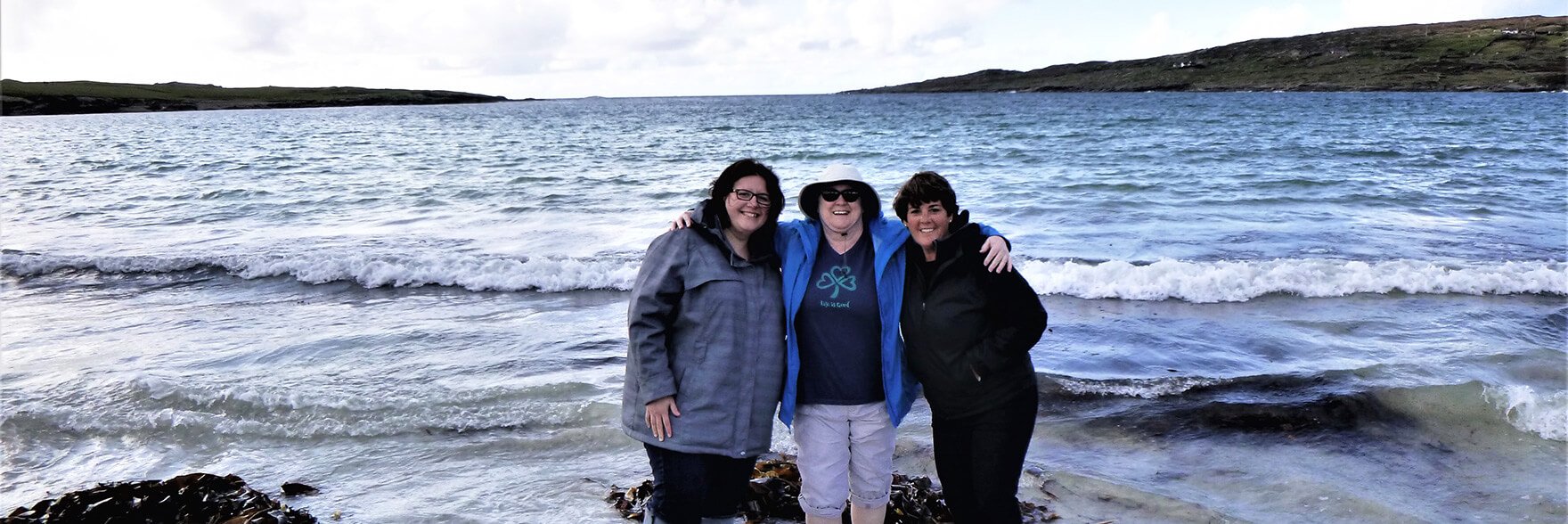 Three tour guests on a beach in Ireland