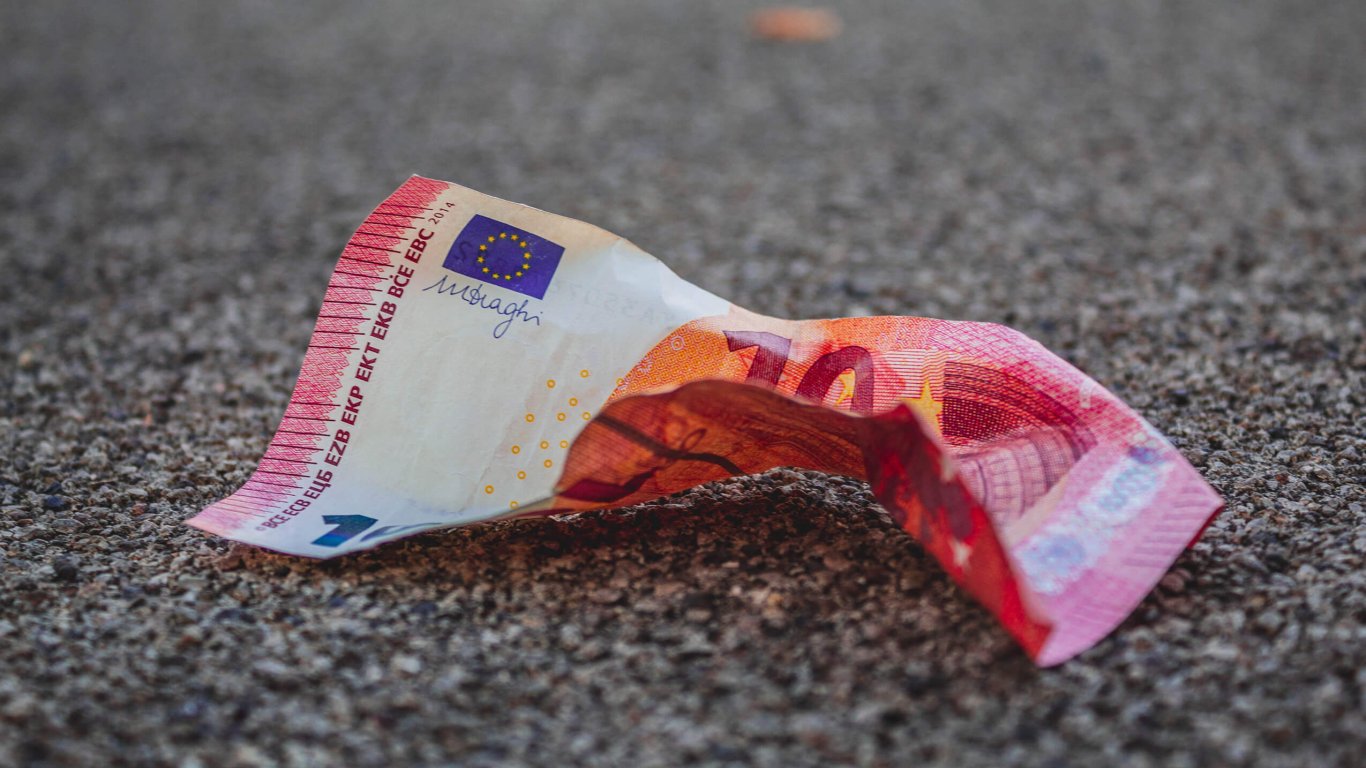 A crumpled up ten euro note on the ground 