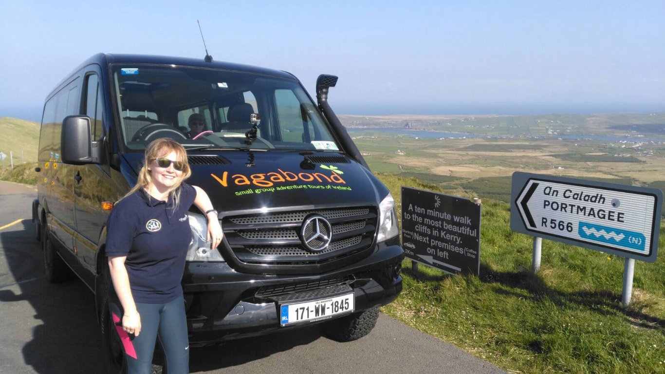 VagaGuide Kim with tour vehicle and roadsigns in Ireland