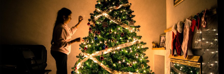 A child decorating her christmas tree in her living room