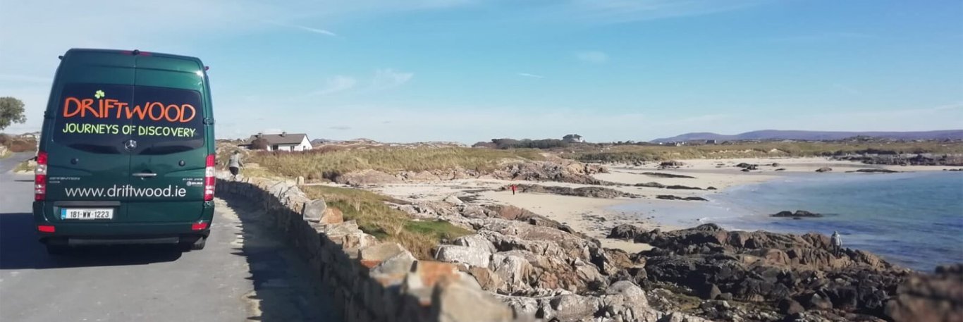 Driftwood tour vehicle beside a beach in Ireland