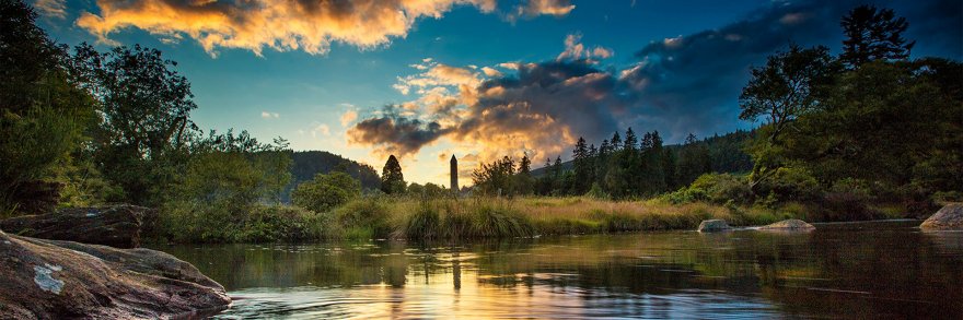 A panoramic view of Glendalough with a view of the lake and the round tower