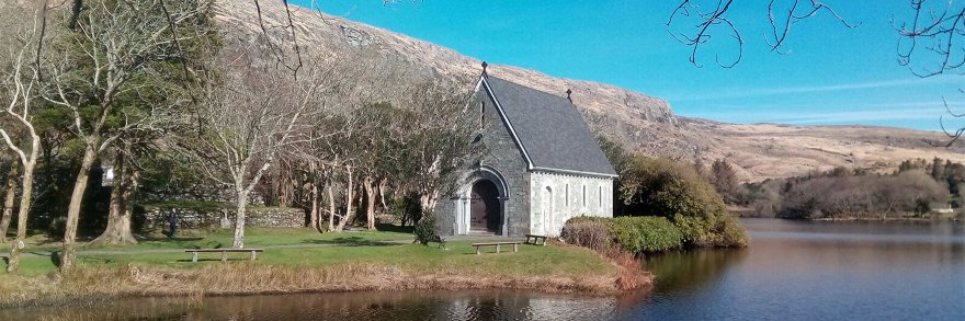 Gougane Barra church on a sunny day with the mountains in the background 