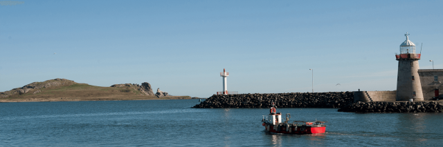 A panoramic view of Howth Harbour with an island in the distance and a lighthouse in view