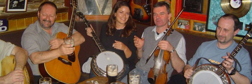 Four trad music players in a pub with their instruments