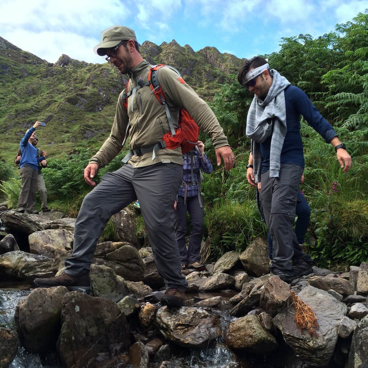 Tour group hiking in Ireland and crossing a river