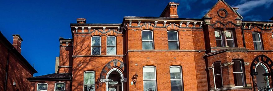Exterior of Roxford Lodge Hotel in Dublin, a redbrick building with blue sky