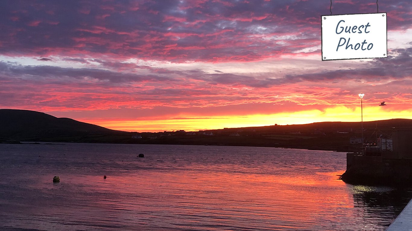 Guest photo of a stunningly colourful orange and pink summer sunset in June in Ireland