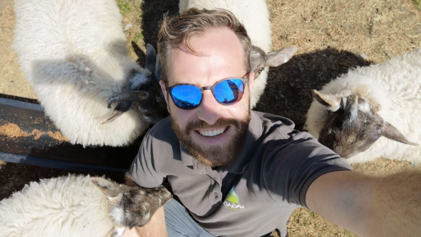 VagaGuide Sean snaps a selfie of himself with some lambs in Ireland