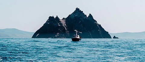 Open ocean with Skellig Michael island in Ireland with boat in foreground