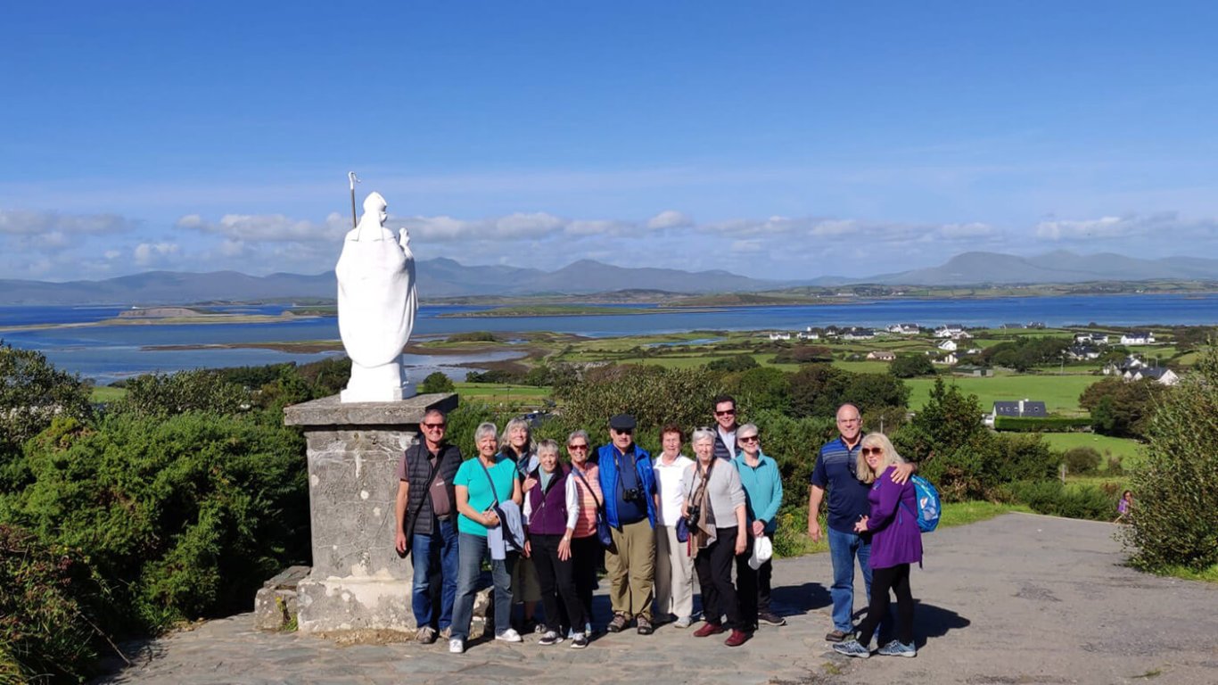 Hiking tour group beside Saint Patrick on Croagh Patrick mountain in Ireland