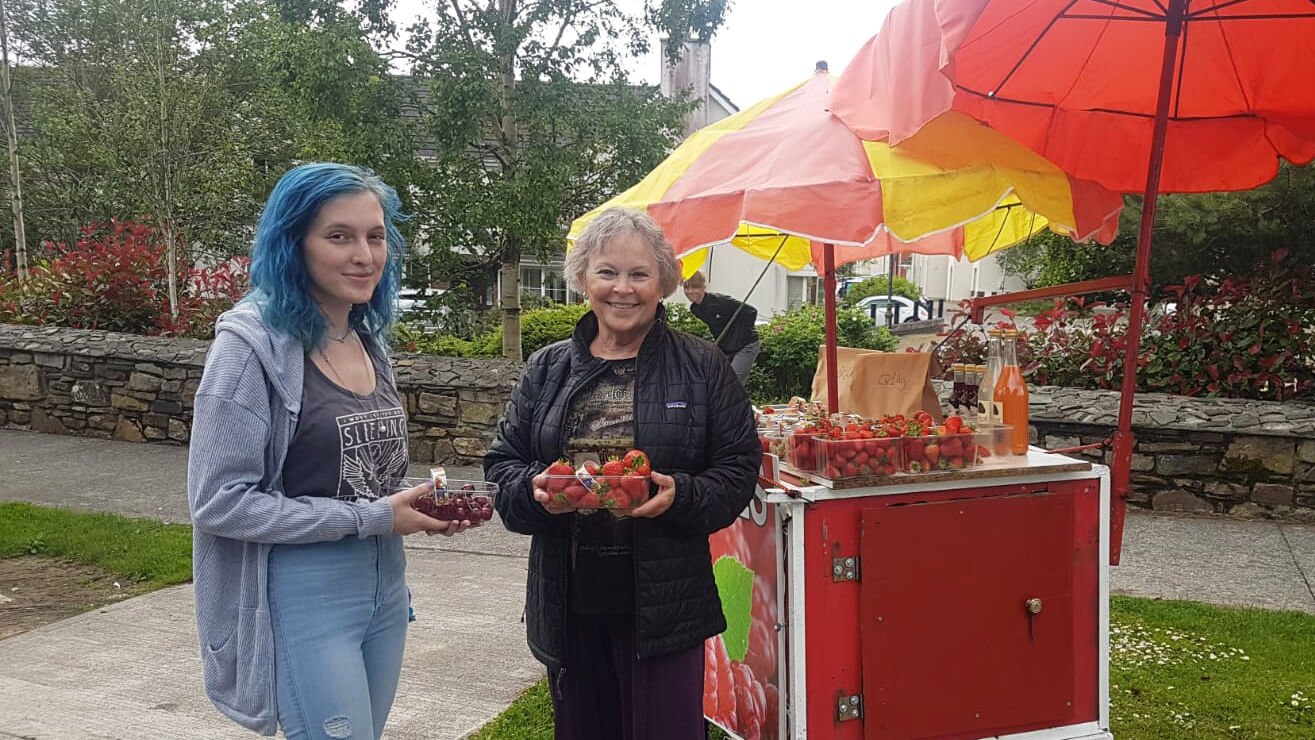 Two female tour guests with strawberries during summer in Ireland