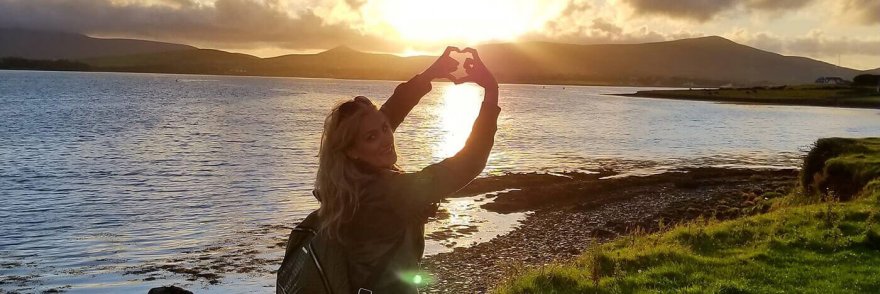 Female tour guest with sunset during summer in Ireland