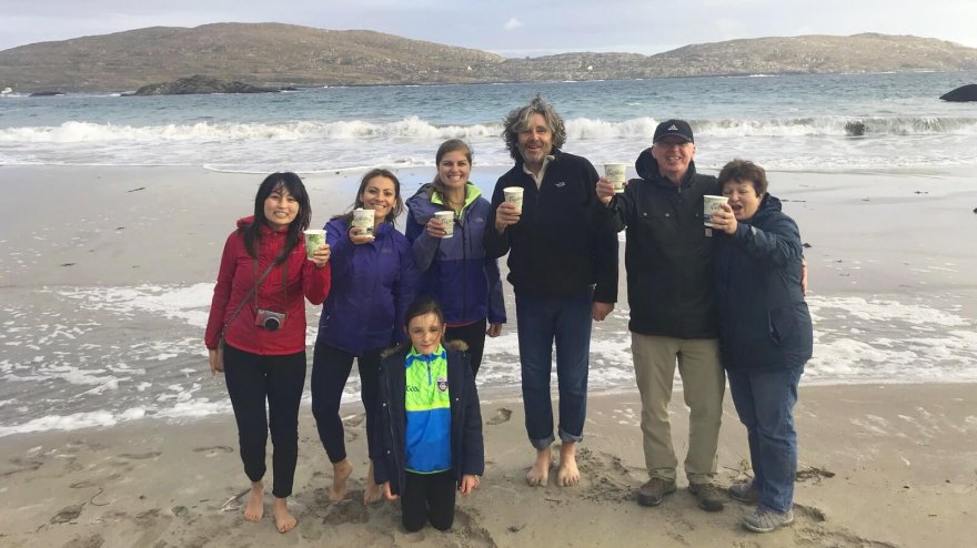 Tour group toasting the camera on a beach in Ireland