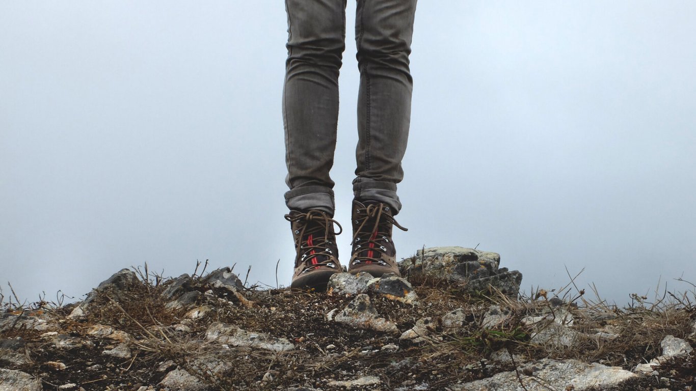 A pair of legs in hiking boots and jeans, standing outdoors