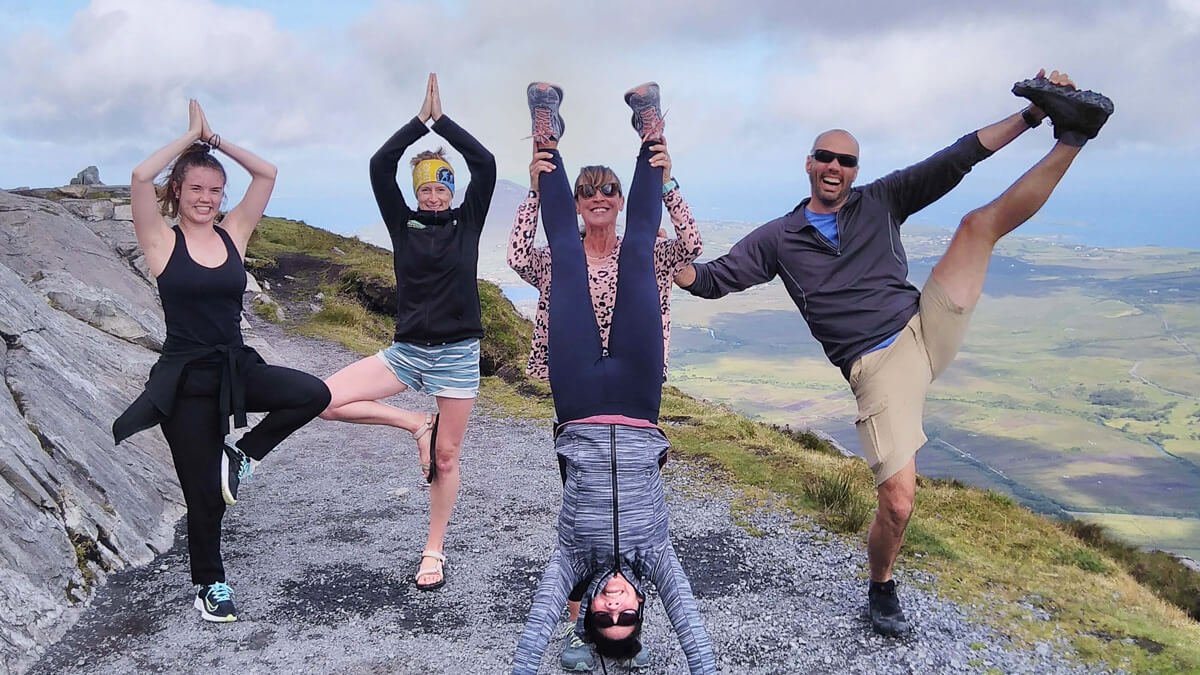 A flexible Vagabond tour group posing athletically while hiking in Ireland