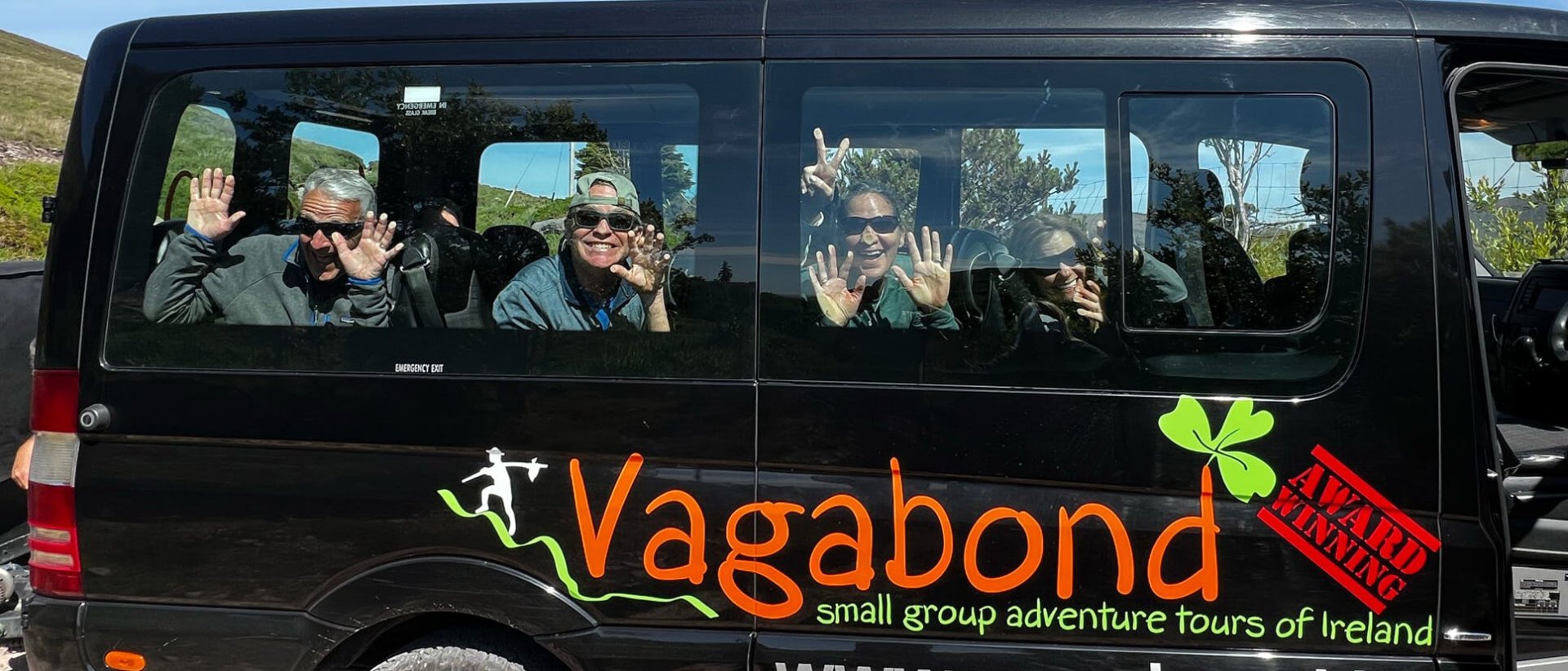 Tour group posing in Ireland in a funny way on a Vagabond minibus