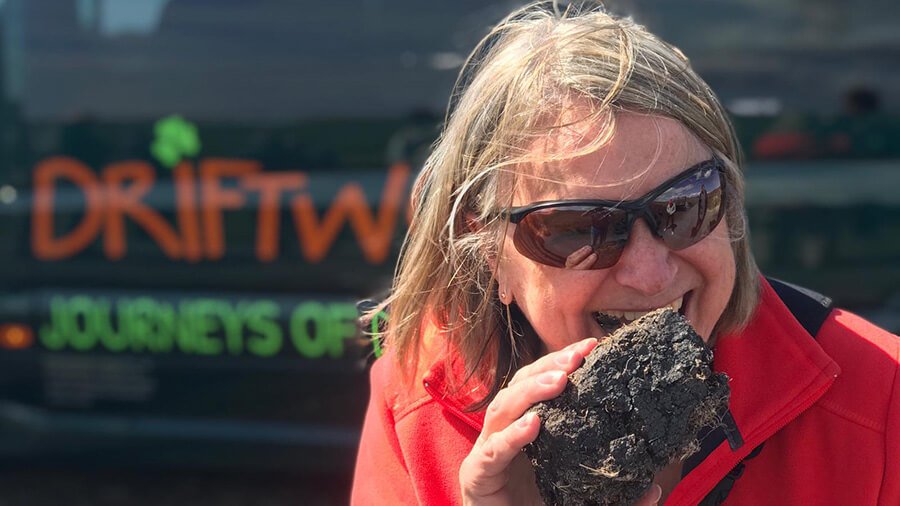 A Driftwood tour guest tastes a piece of turf from an Irish bog