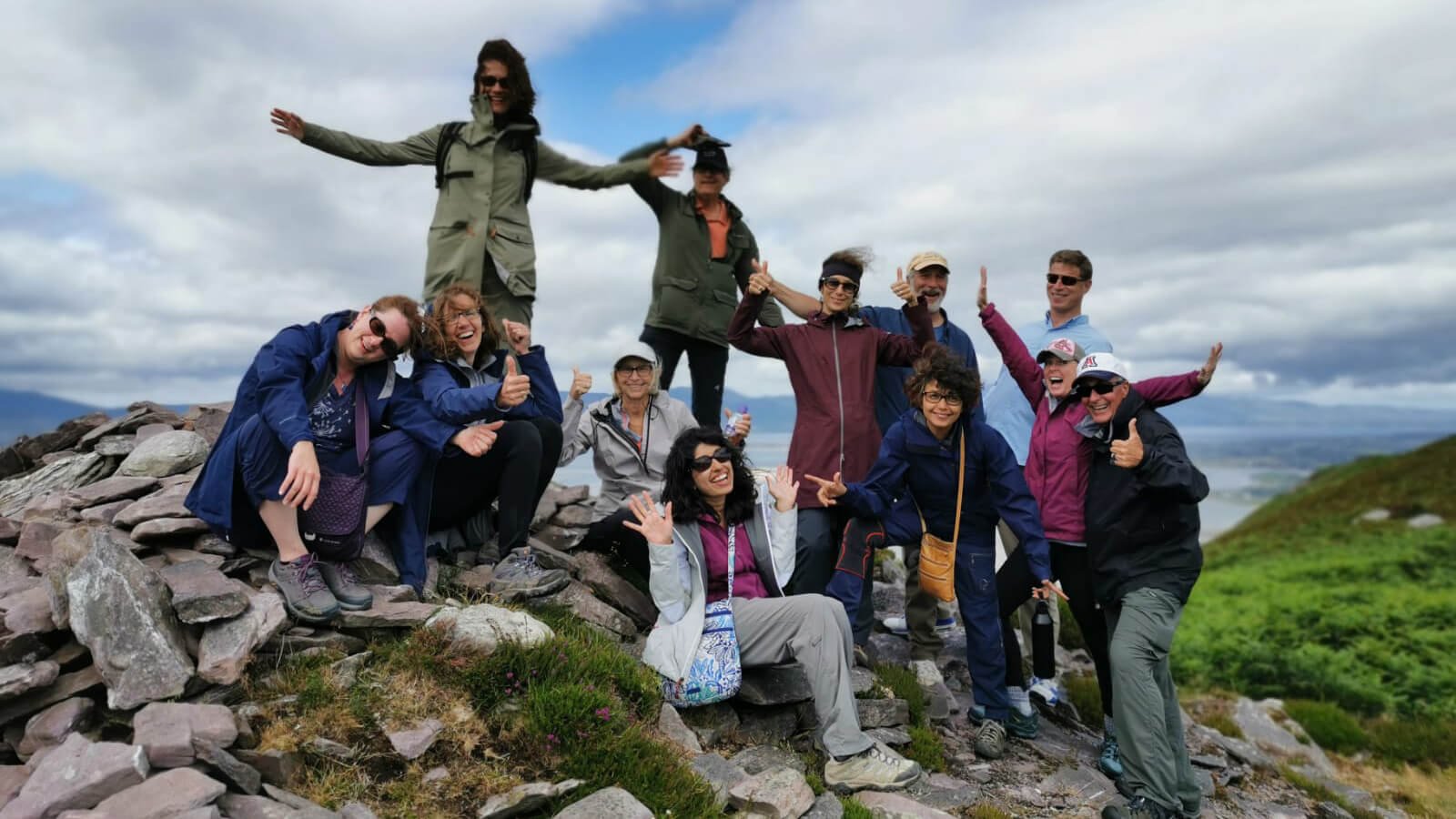 Happy tour group who have reached the summit of a mountain in Ireland