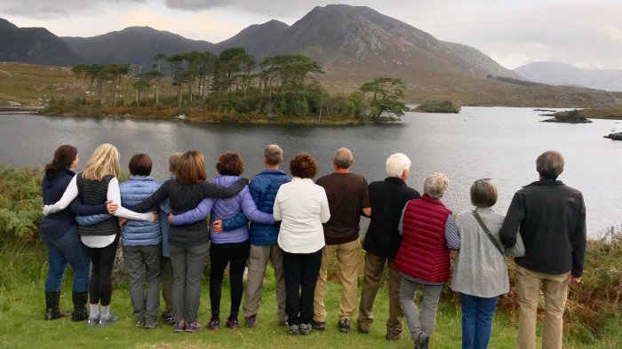Tour group with their backs to camera admiring a scenic view in Connemara, Ireland