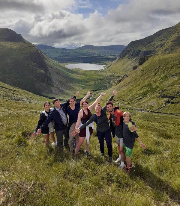 Happy young hiking group in a green valley in Ireland