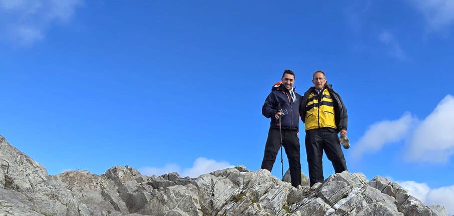 Two tour guests hiking in Ireland with blue sky in background