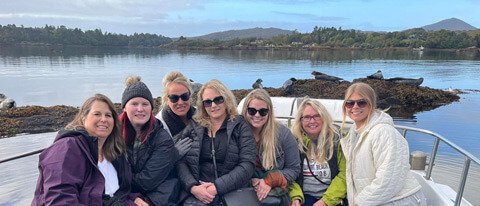 Ireland tour group on a boat trip beside seals in scenic setting
