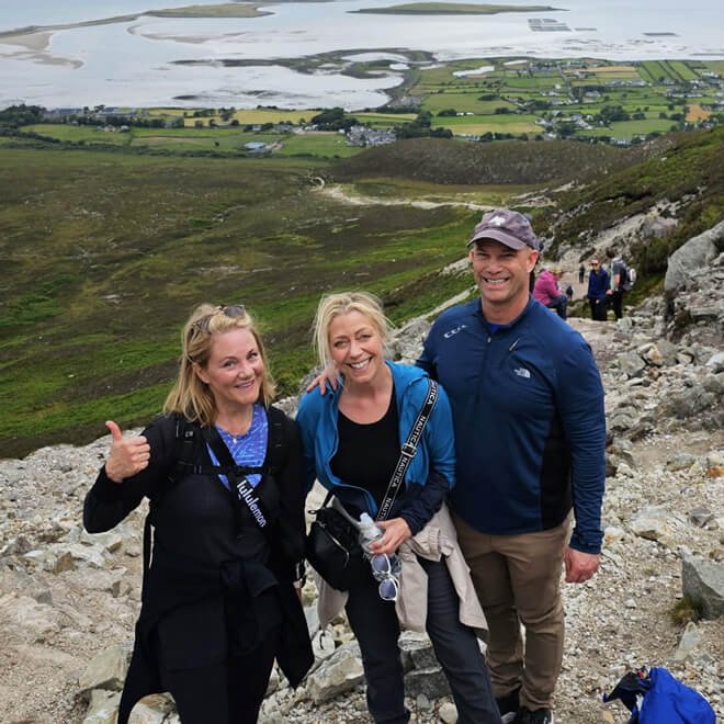 A trio of hikers smiling on Croagh Patrick mountain in Ireland