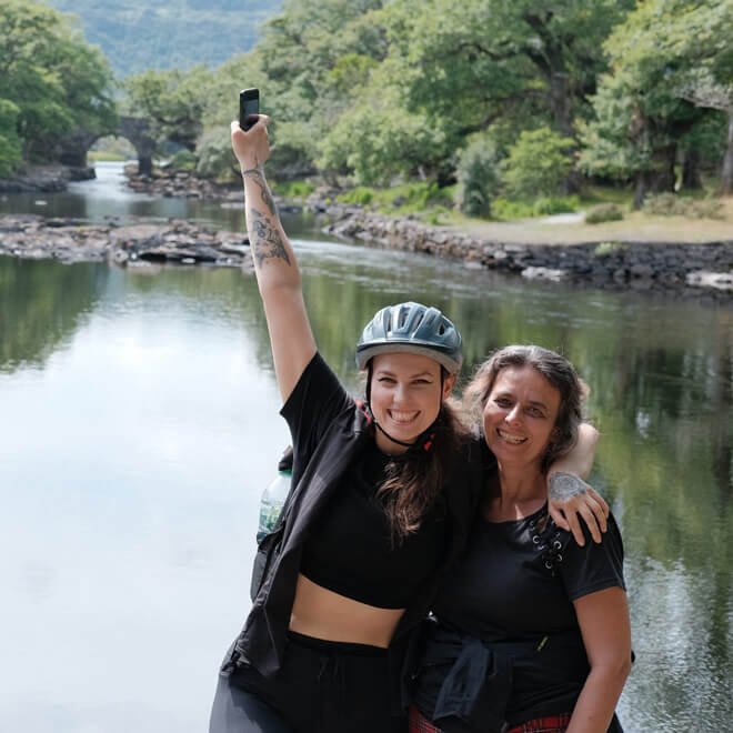 Two happy tour guests beside a lake in Ireland