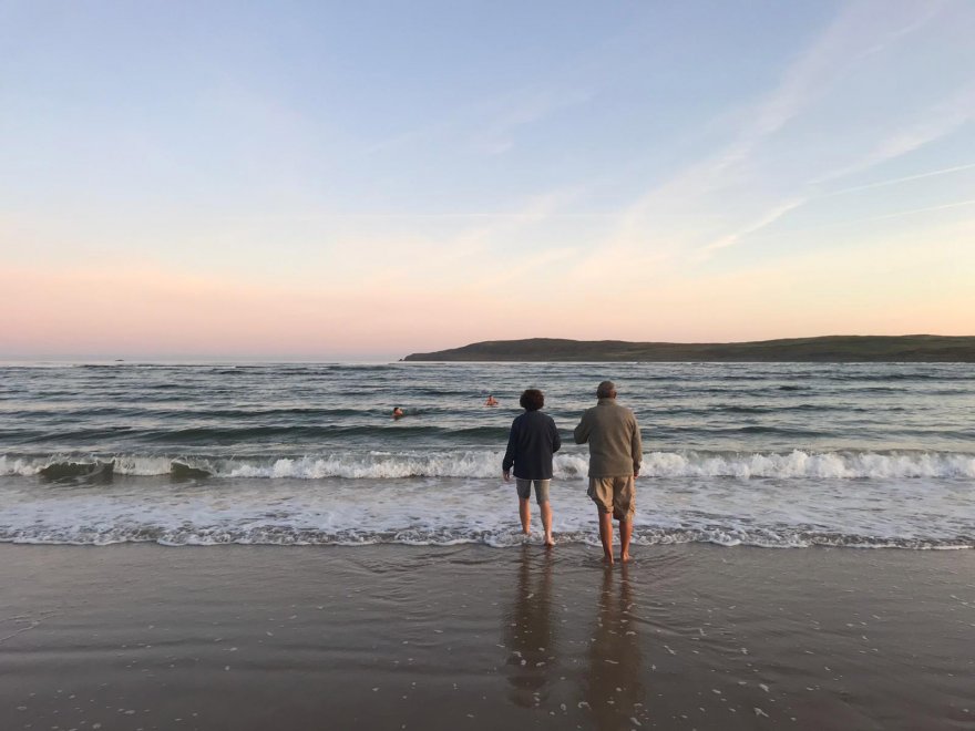 A couple enjoying a sunrise on the beach