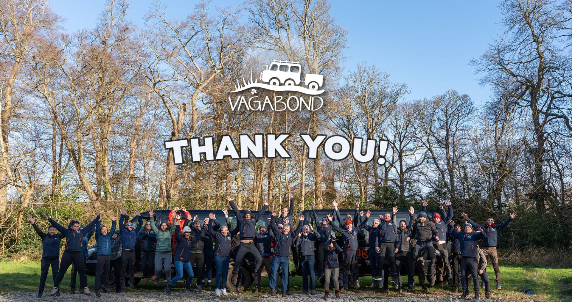 Tour guide team in meadow with Vagabond logo and vehicles