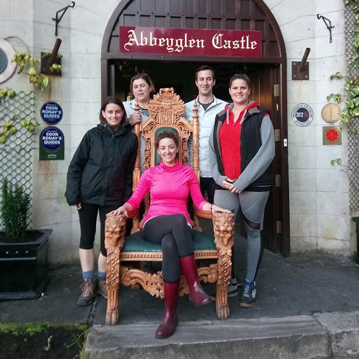 Family posing for a picture with woman sitting on the throne in front of Abbeyglen Castle