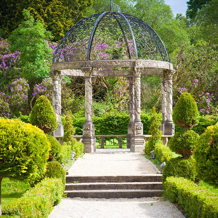 A round pergola in the gardens of Ballyseede Castle surrounded by beautiful flowers and trees