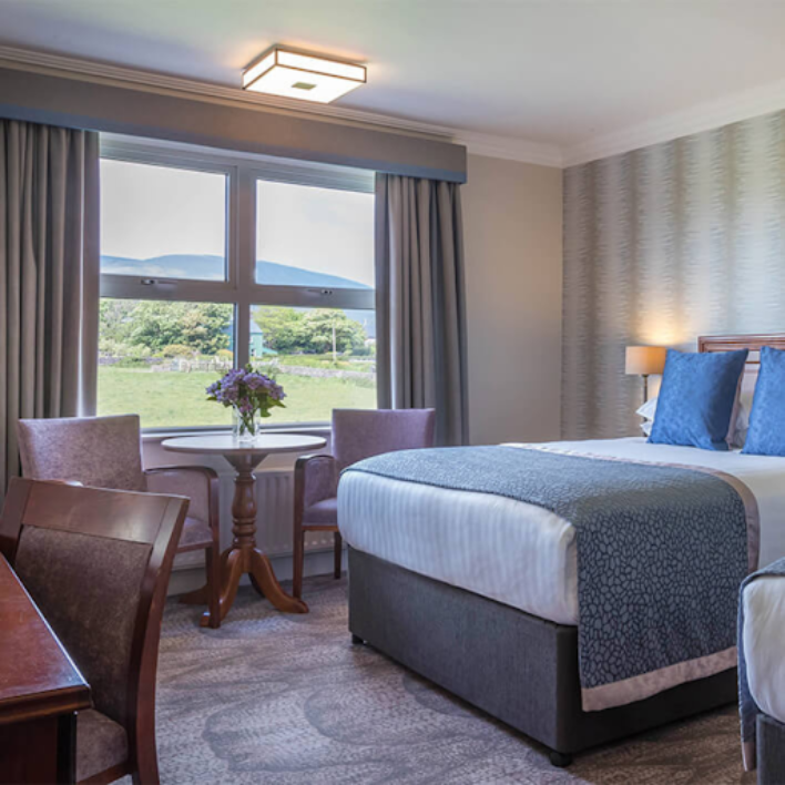 A double room in the dingle skellig hotel with a nice view out the window of a field