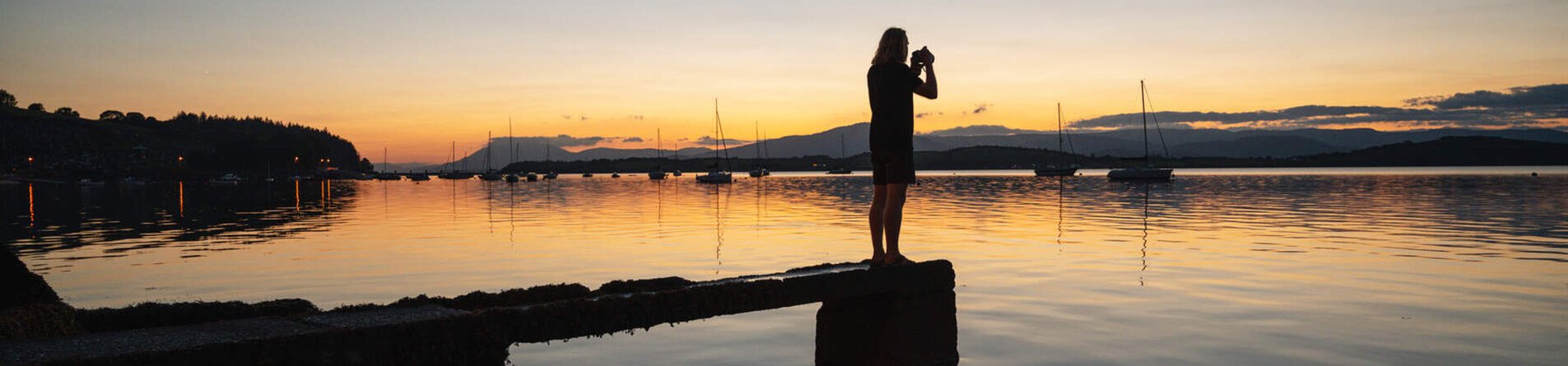 Photographer taking picture of sunset in Bantry Bay, Cork