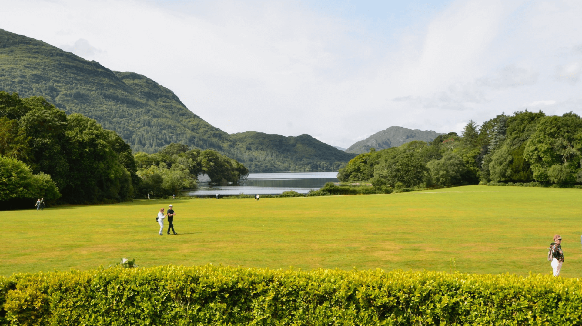 A view of killarney national park with people walking through the grass