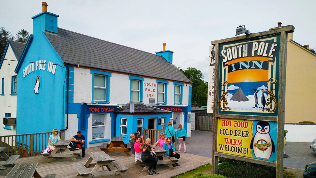 A Vagabond group sitting on the benches outside the South Pole Inn having a drink