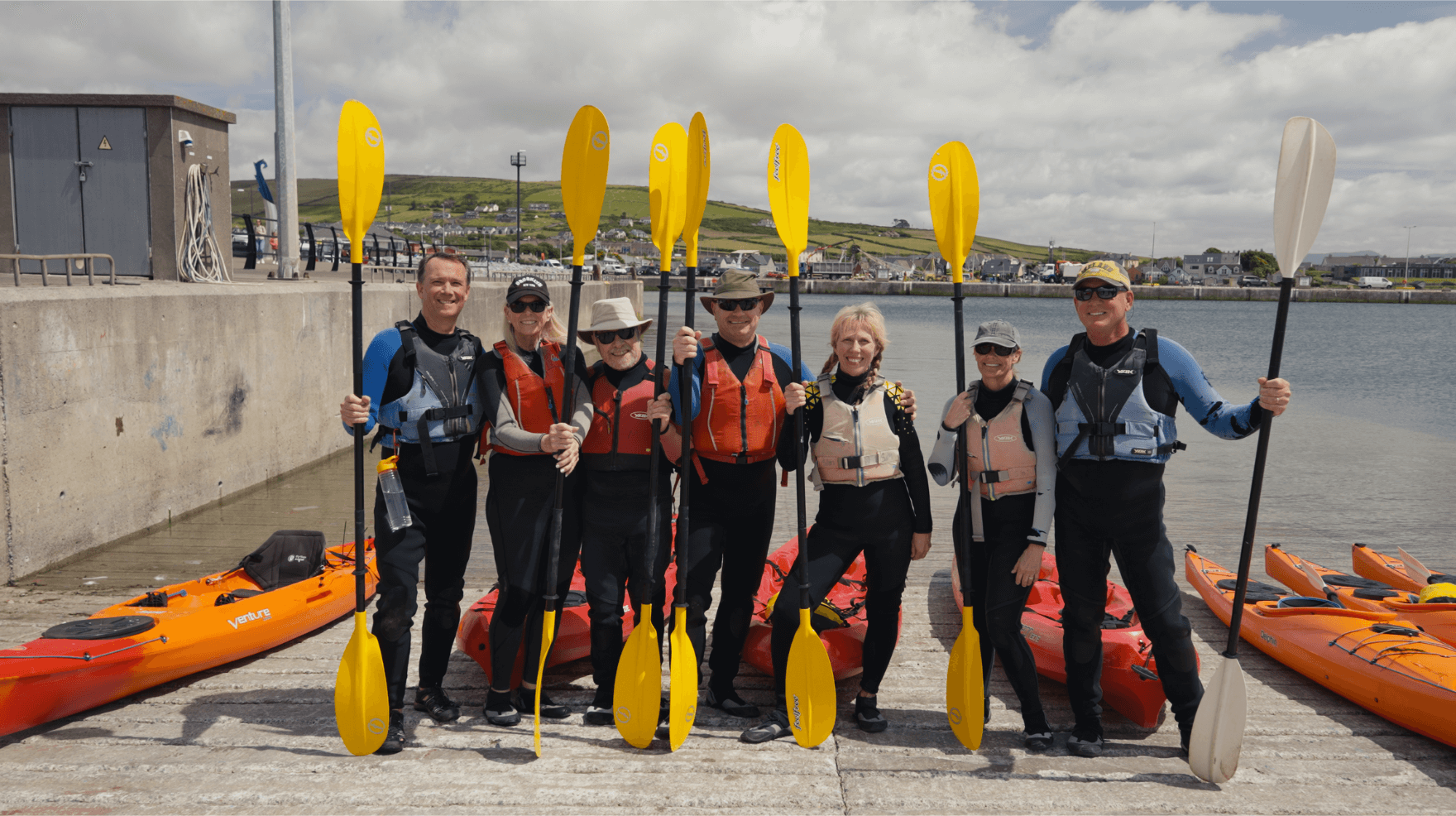 A group of guests posing on Dingle harbour before getting into their kayaks