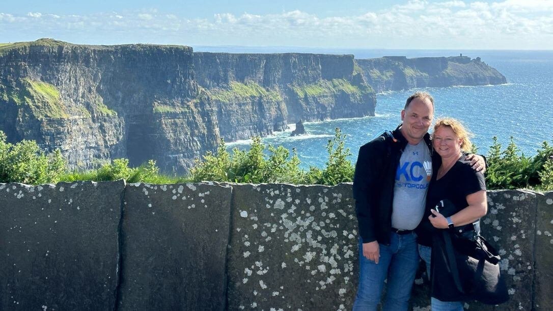 A couple posing in front of the cliffs of moher